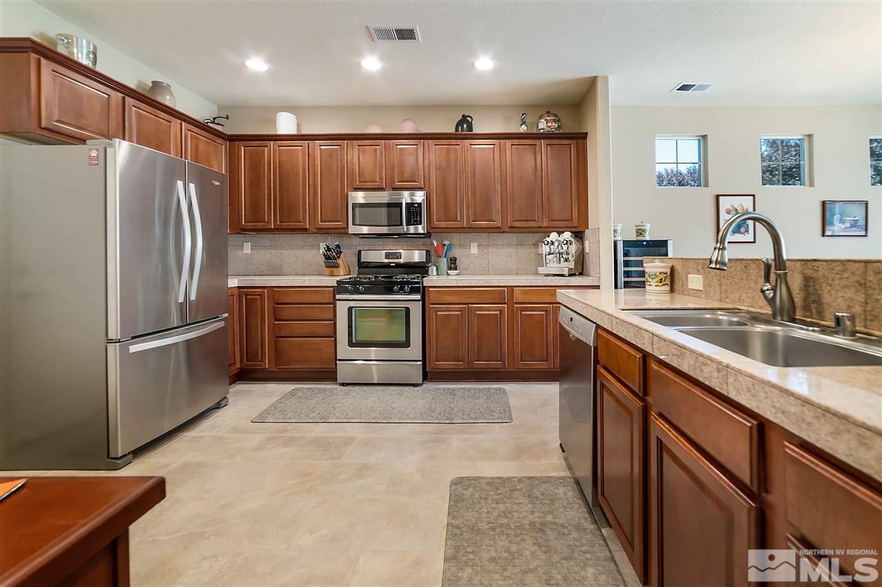 1875 Stetson Drive Reno, NV 89521 - Photo 5 of 27 a kitchen with stainless steel appliances granite countertop a sink stove and refrigerator