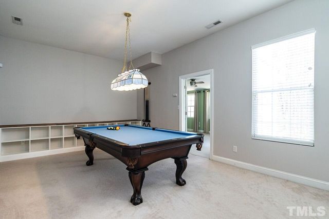 a room with pool table and windows