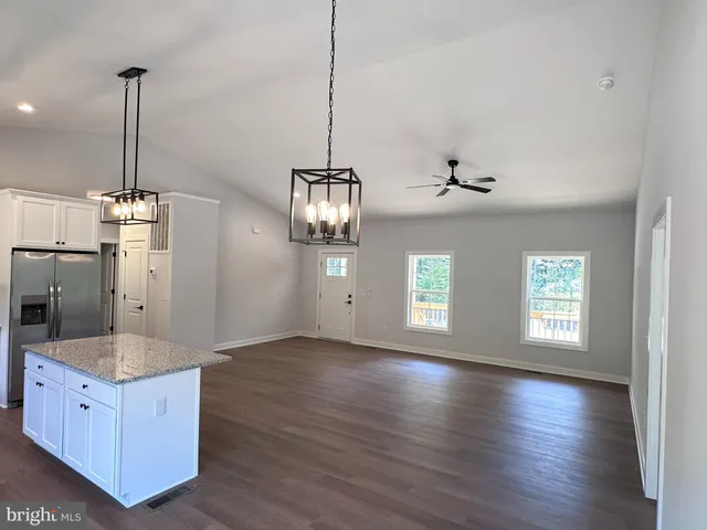 a kitchen with stainless steel appliances granite countertop wooden floors and granite counter tops