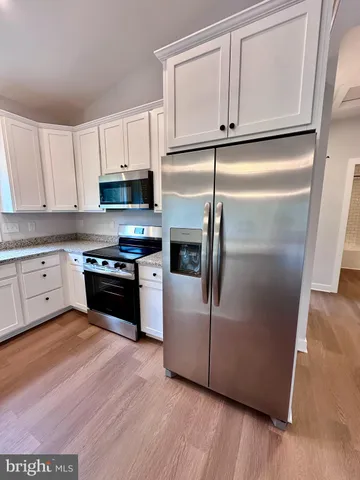 a kitchen with granite countertop a refrigerator a sink and a stove
