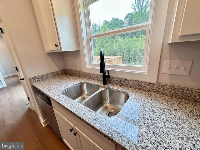 a kitchen with a sink a counter top space and cabinets