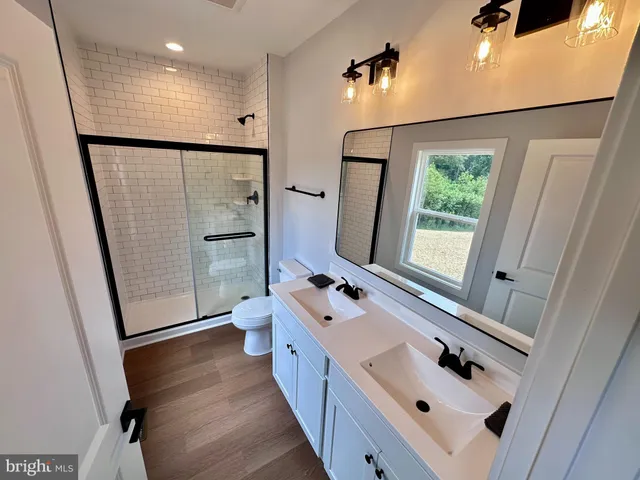 a bathroom with a double vanity sink a mirror and a shower
