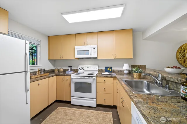 a kitchen with a sink stove top oven and refrigerator