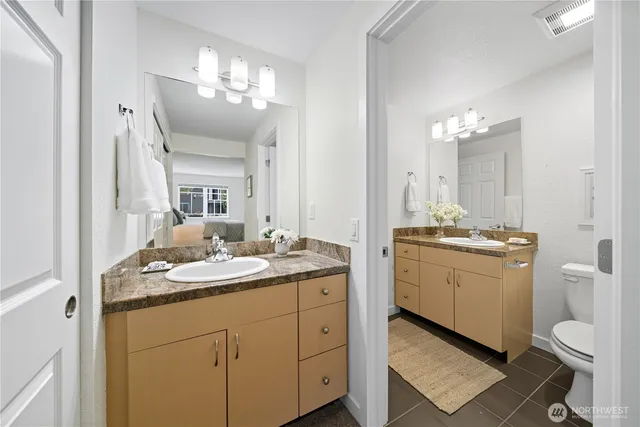 a bathroom with a granite countertop sink a toilet and mirror