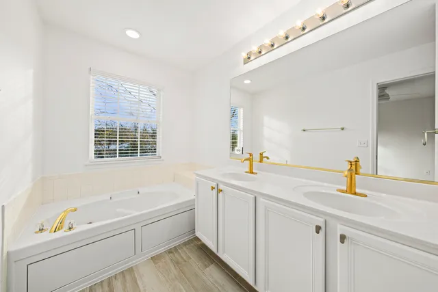 a bathroom with a tub a sink and a window