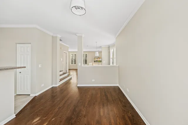 a view of a big room with wooden floor and windows