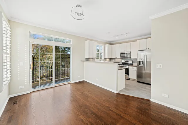 a view of kitchen with wooden floor and electronic appliances