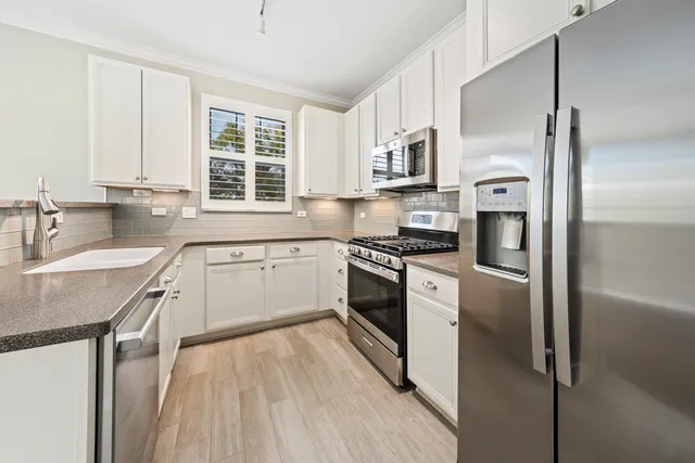 a kitchen with white cabinets and white appliances