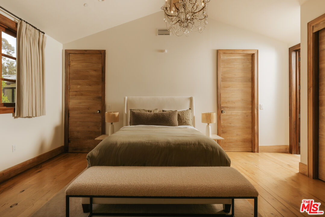 1105 Rivas Canyon Road Pacific Palisades, CA 90272 - Photo 37 of 49 a bedroom with a bed and wooden floor
