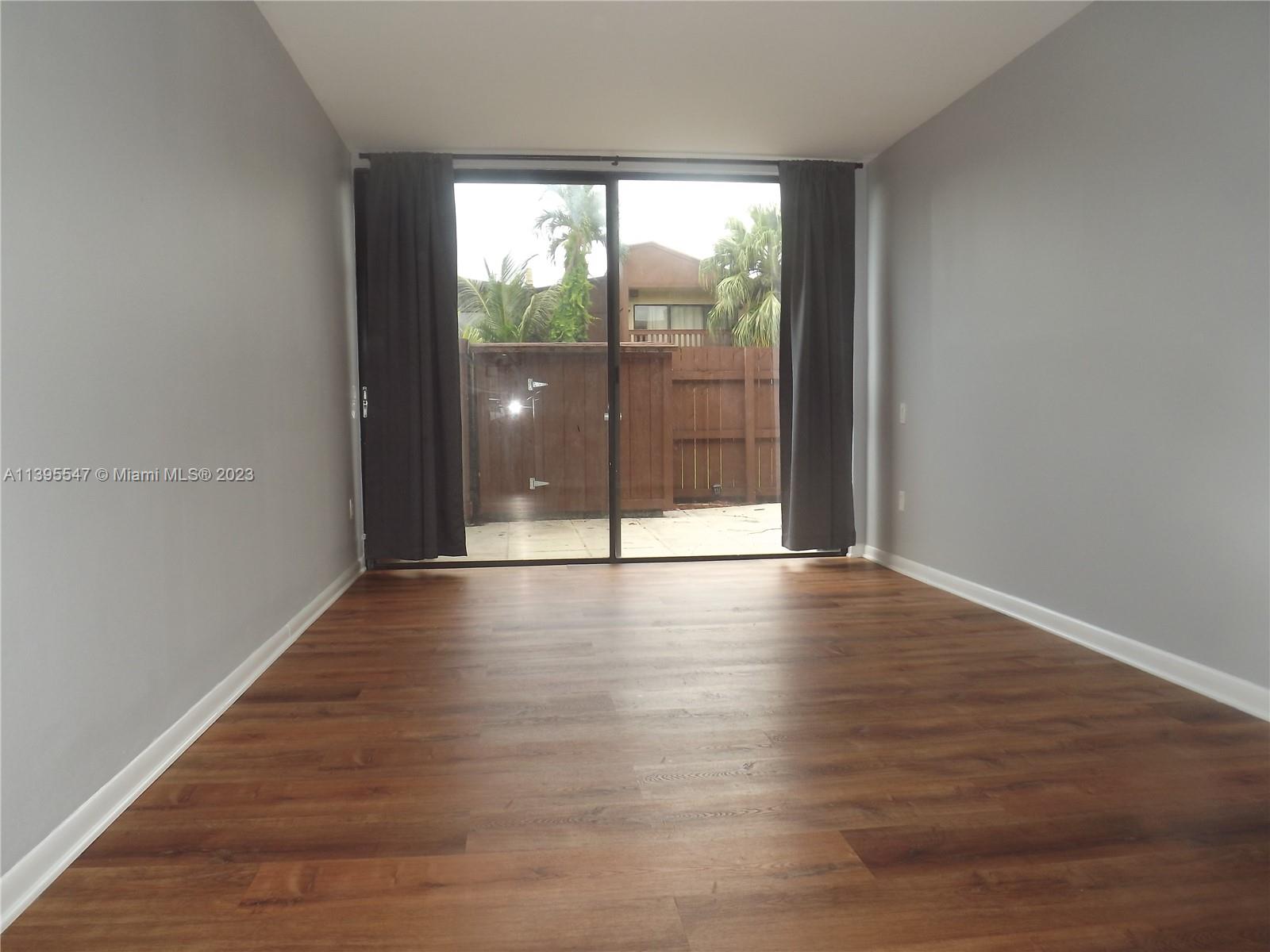 Kendall Miami, FL 33173 - Photo 15 of 34 an empty room with wooden floor and windows
