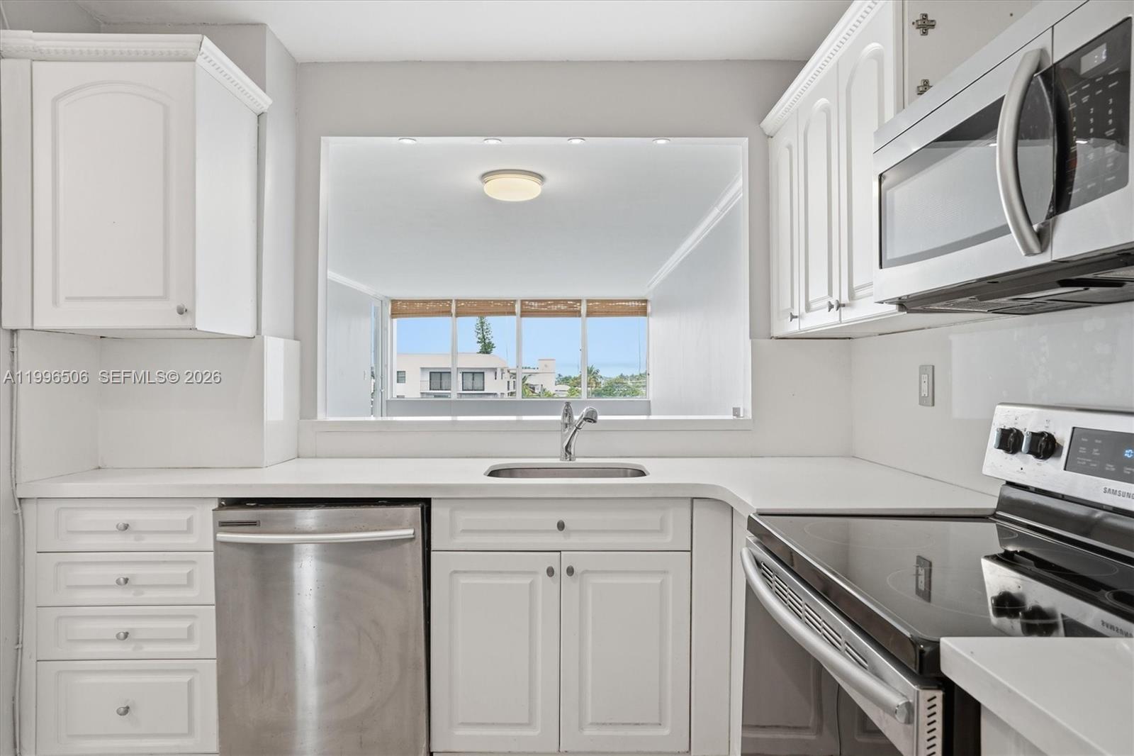 8233 Harding Avenue, Unit 504 Miami Beach, FL 33141 - Photo 10 of 24 a kitchen with white cabinets and a sink
