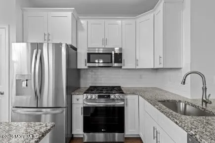 a kitchen with stainless steel appliances granite countertop a stove a refrigerator and a sink