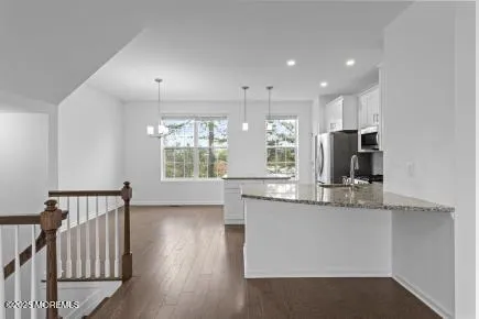 a kitchen with stainless steel appliances granite countertop a refrigerator a stove a sink and a microwave