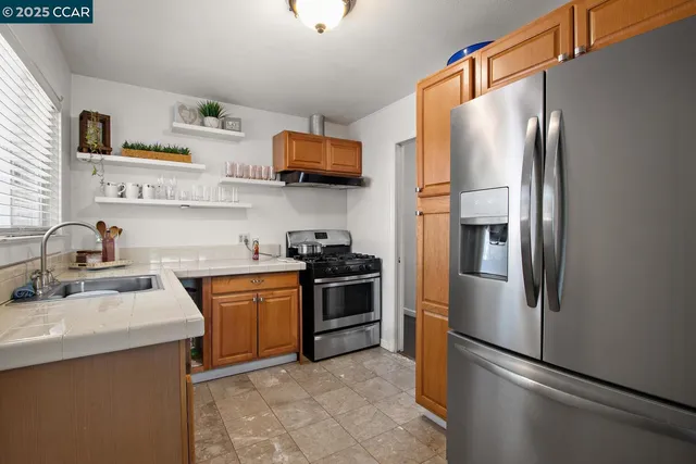 a kitchen with stainless steel appliances granite countertop a refrigerator sink and stove
