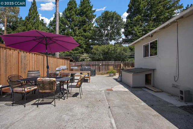 a view of a patio with chairs and umbrellas