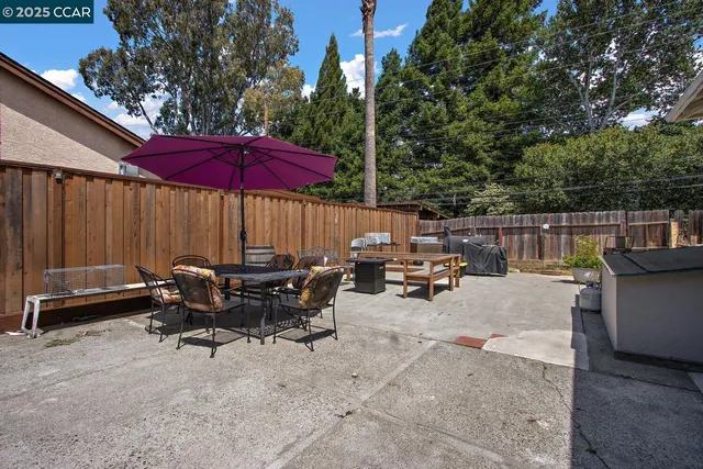 a view of a patio with a table and chairs under an umbrella