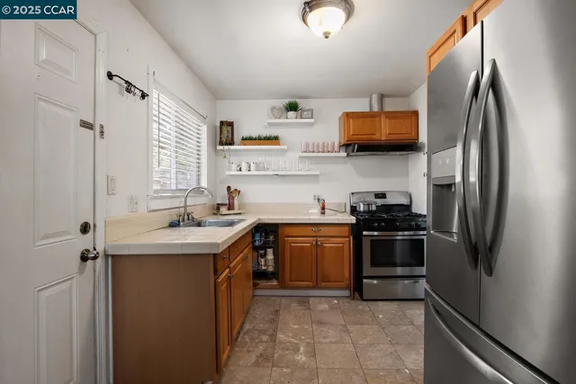 a kitchen with stainless steel appliances granite countertop a refrigerator stove and sink
