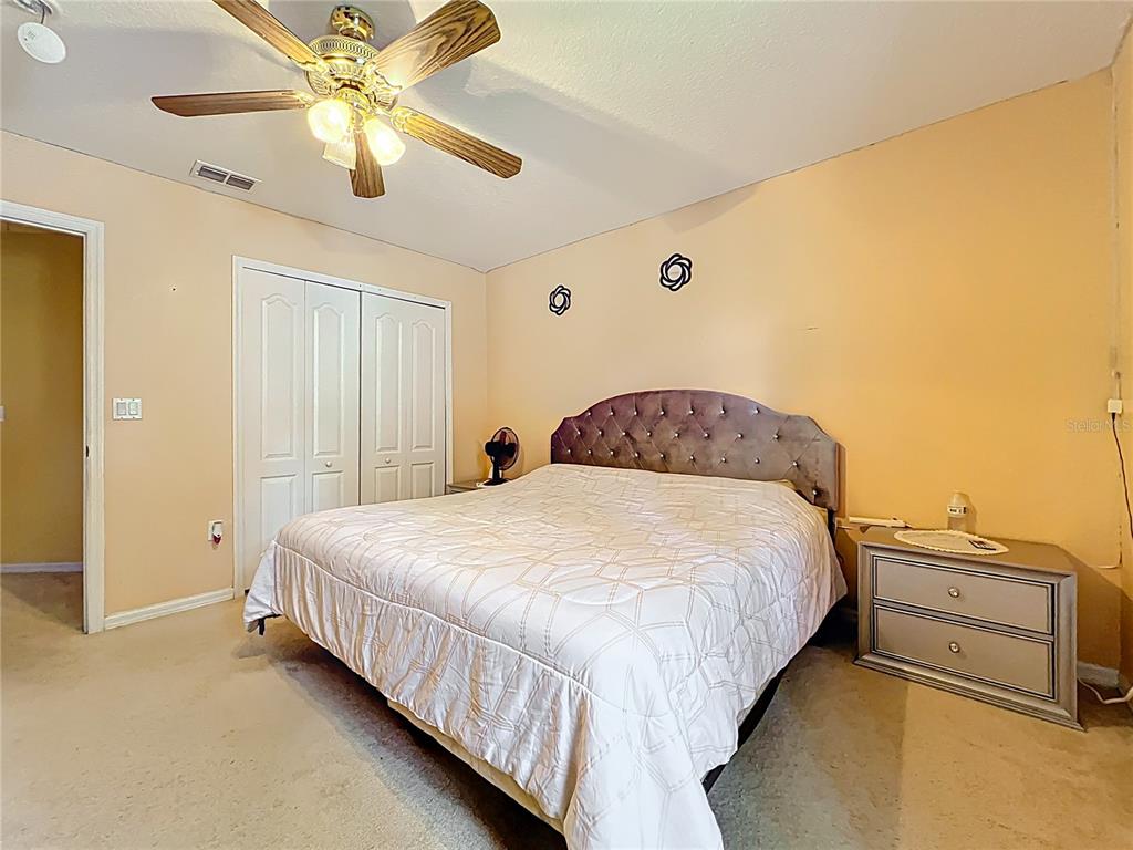 7939 Riffle Lane Orlando, FL 32818 - Photo 35 of 52 a bedroom with a bed and a ceiling fan