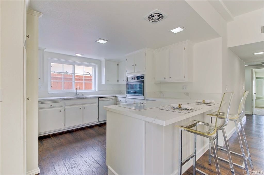2814 Serang Place Costa Mesa, CA 92626 - Photo 14 of 28 a kitchen that has a cabinets counter space and a stove