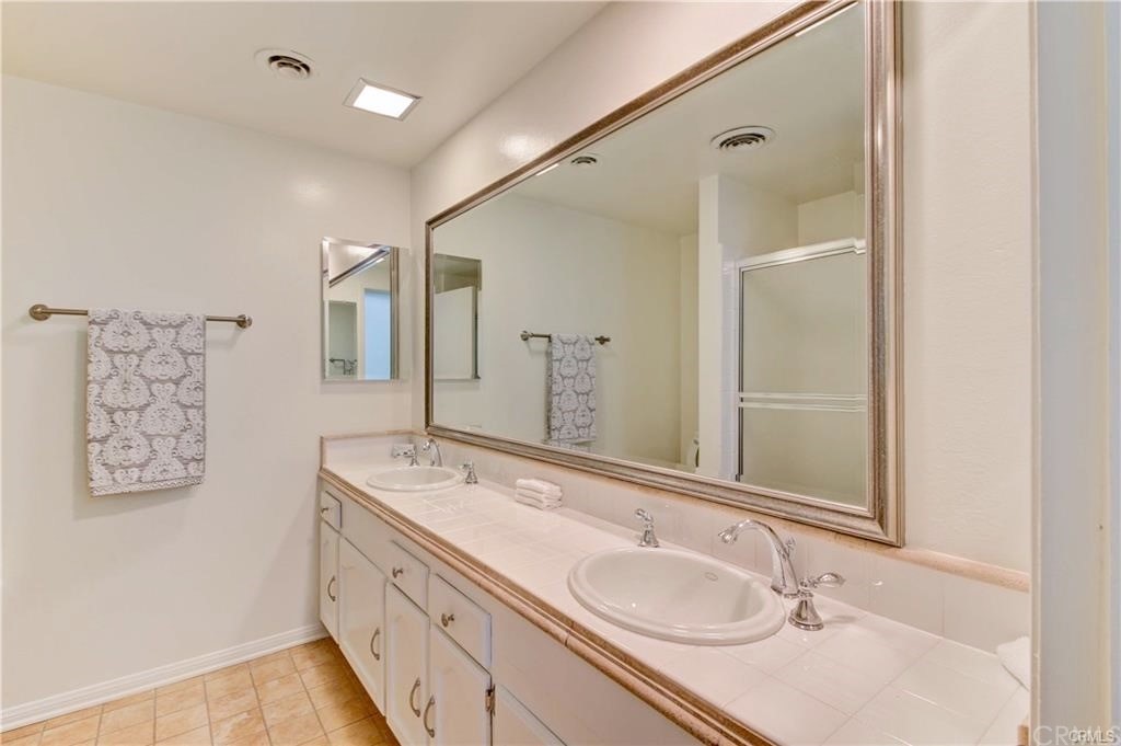 2814 Serang Place Costa Mesa, CA 92626 - Photo 23 of 28 a bathroom with a granite countertop double vanity sink and a mirror