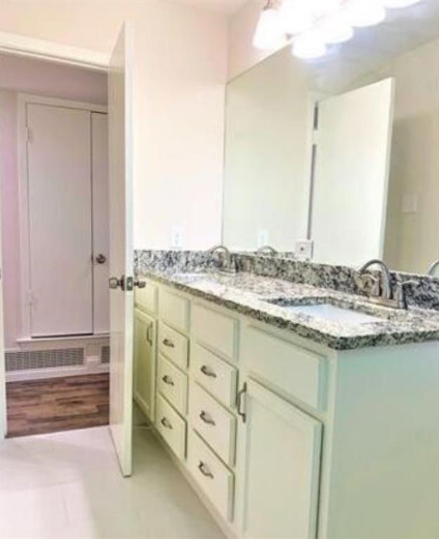 2536 Rutherford Street Irving, TX 75062 - Photo 2 of 19 Dual vanity with white cabinetry, integrated sinks, granite-look countertop, and individual chrome faucets
