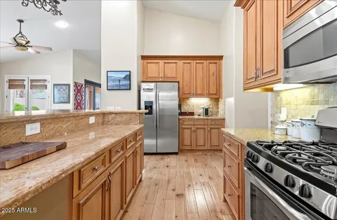 a dining room with wooden floor a chandelier a wooden table and chairs