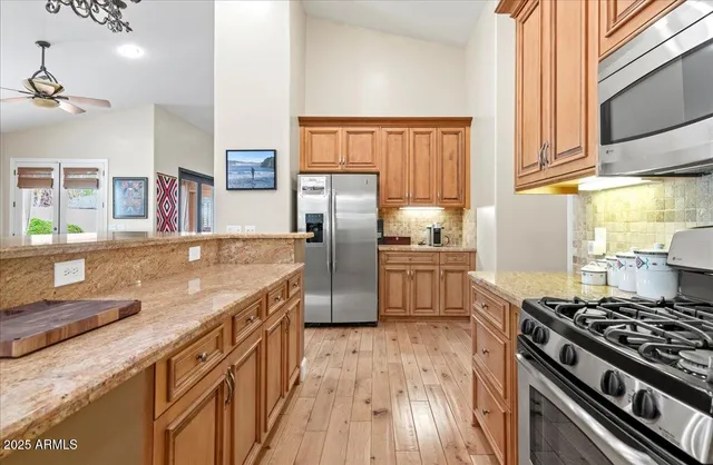 a dining room with wooden floor a chandelier a wooden table and chairs