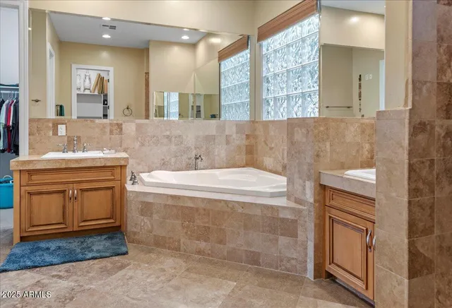a bathroom with a tub sink and mirror