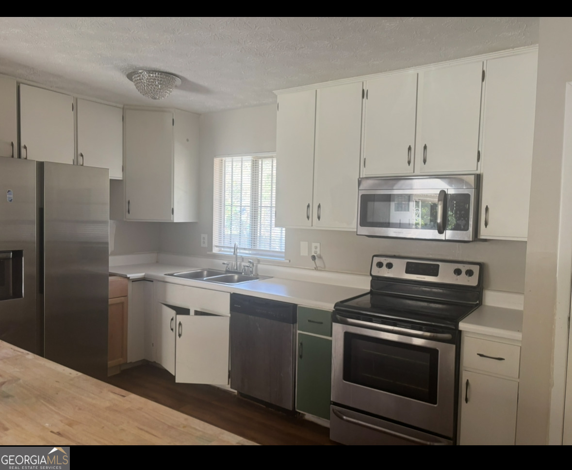 602 Dixon Road Jonesboro, GA 30238 - Photo 3 of 4 a kitchen with appliances cabinets and a sink