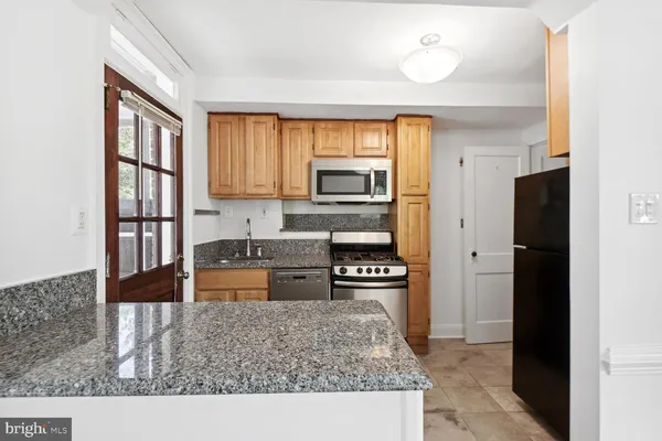 a kitchen with stainless steel appliances granite countertop a refrigerator and a stove top oven