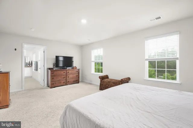 a spacious bedroom with a bed and window
