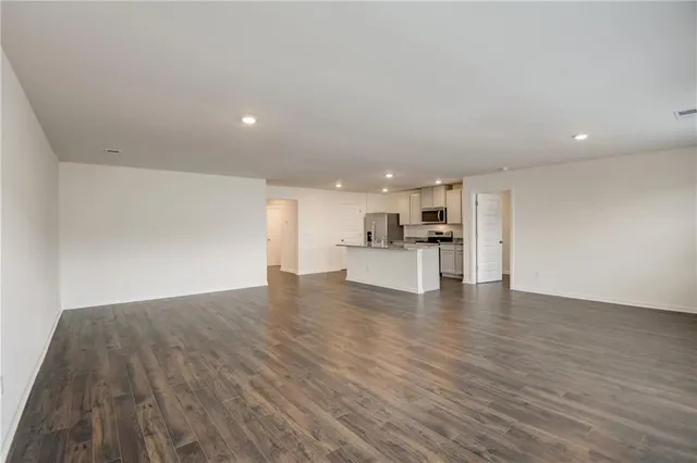 a view of kitchen with kitchen island wooden floors and stainless steel appliances
