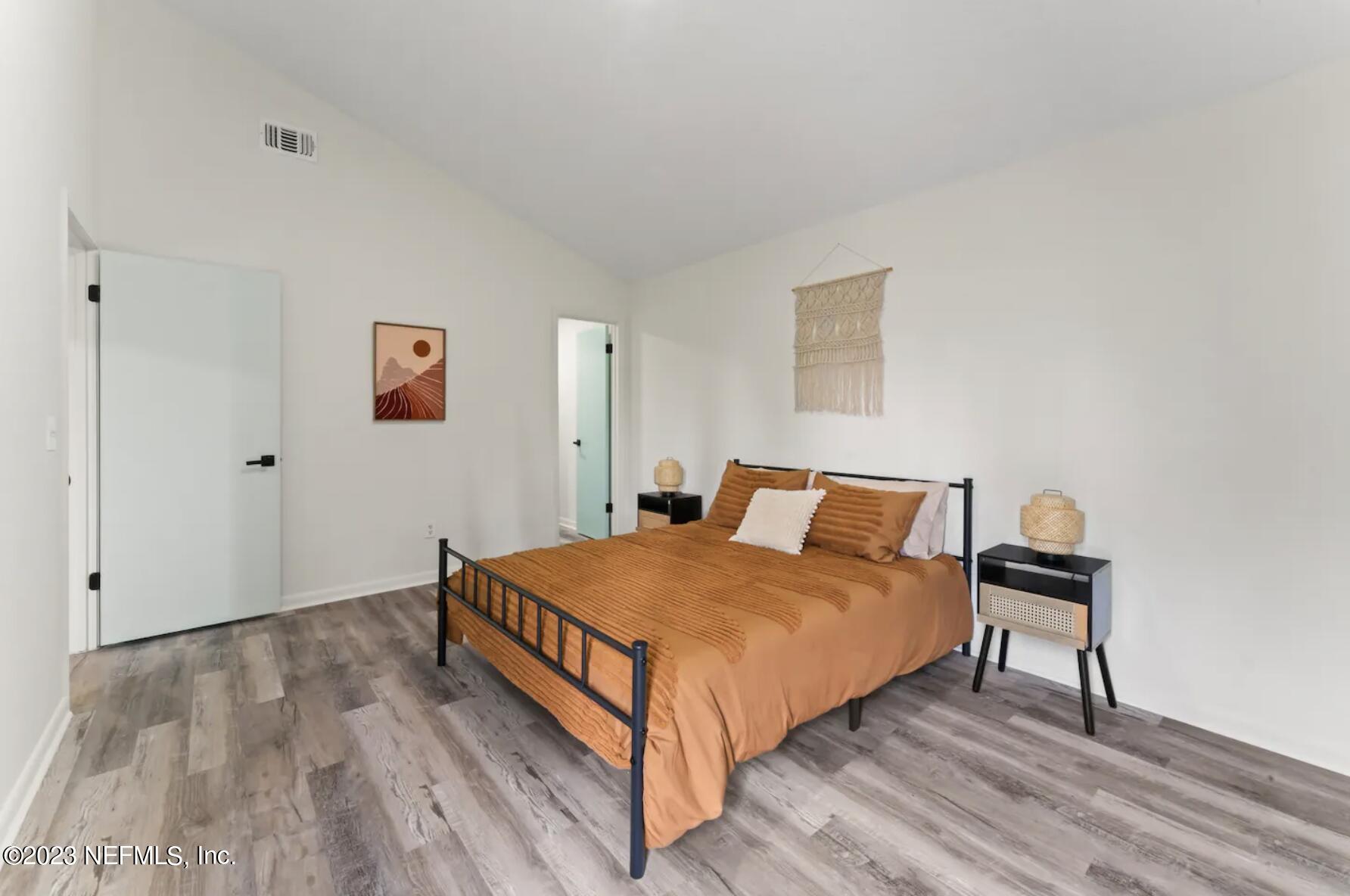10711 Alden Road, Unit 4 Jacksonville, FL 32246 - Photo 14 of 18 a bedroom with a bed and wooden floor