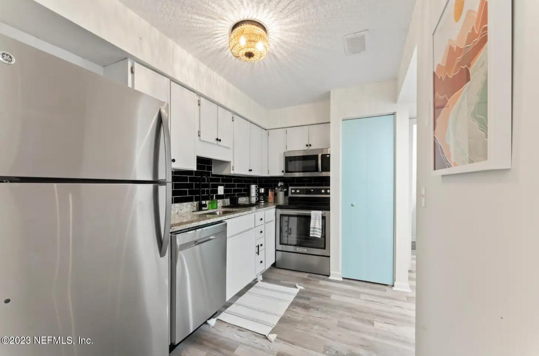 10711 Alden Road, Unit 4 Jacksonville, FL 32246 - Photo 4 of 18 a kitchen with stainless steel appliances granite countertop a refrigerator a stove a sink and dishwasher