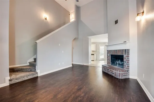 a view of a livingroom with wooden floor and a fireplace