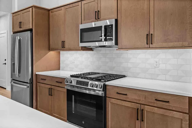 a kitchen with stainless steel appliances white cabinets and a stove top oven