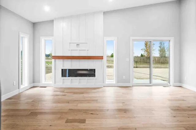 a view of empty room with wooden floor and fireplace