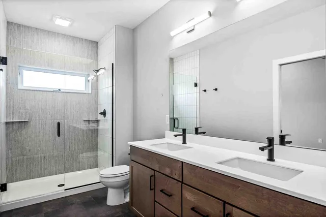 a bathroom with a double vanity sink toilet and shower