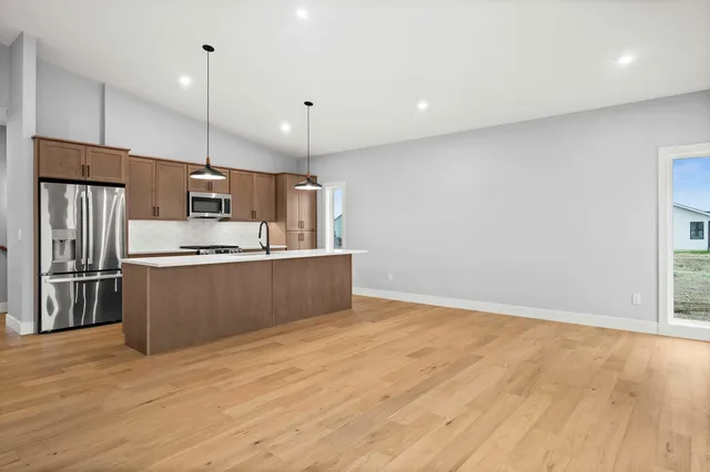 a large kitchen with a large counter top stainless steel appliances and cabinets