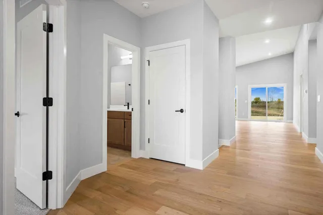 a view of a hallway with wooden floor and closet area