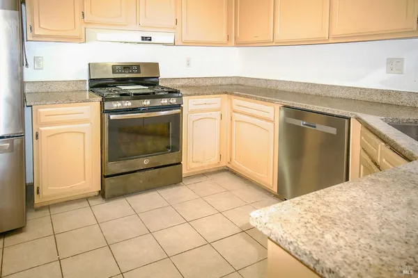 a kitchen with a stove top oven and cabinets
