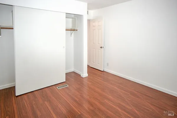 an empty room with wooden floor and a window