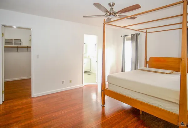 a bedroom with a bed and wooden floor