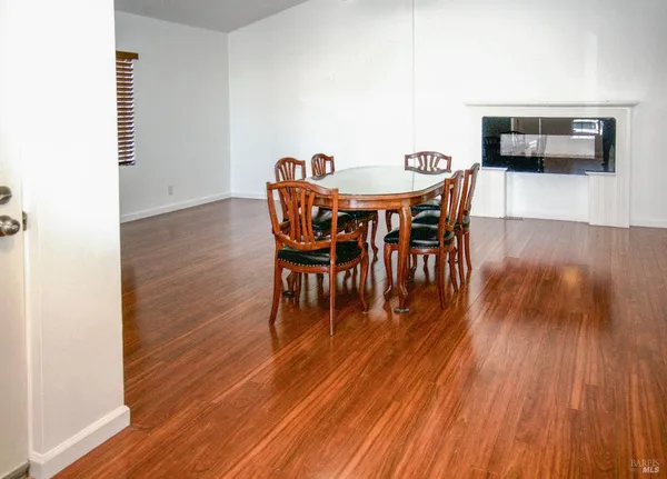 a dining room with furniture wooden floor a rug and a painting