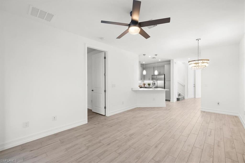 7622 Rockefeller Drive Naples, FL 34119 - Photo 11 of 40 a view of a livingroom with wooden floor and a ceiling fan