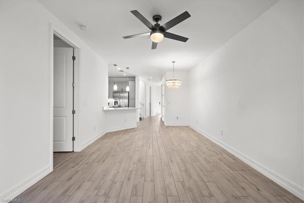 7622 Rockefeller Drive Naples, FL 34119 - Photo 12 of 40 an empty room with wooden floor ceiling fan and windows