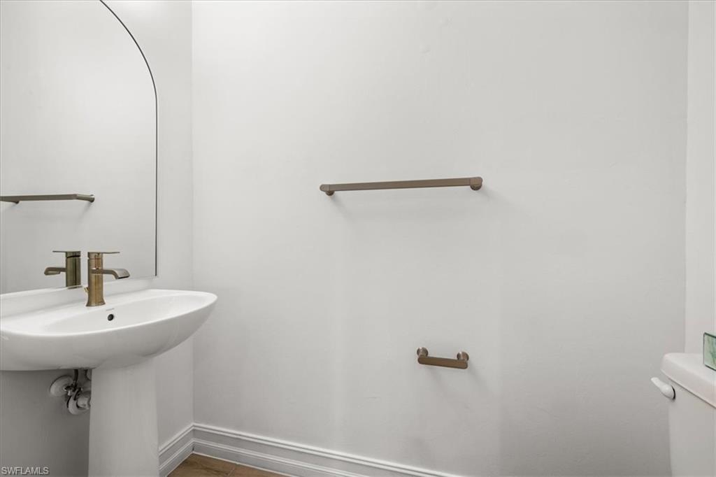 7622 Rockefeller Drive Naples, FL 34119 - Photo 24 of 40 a bathroom with a sink a mirror and a toilet