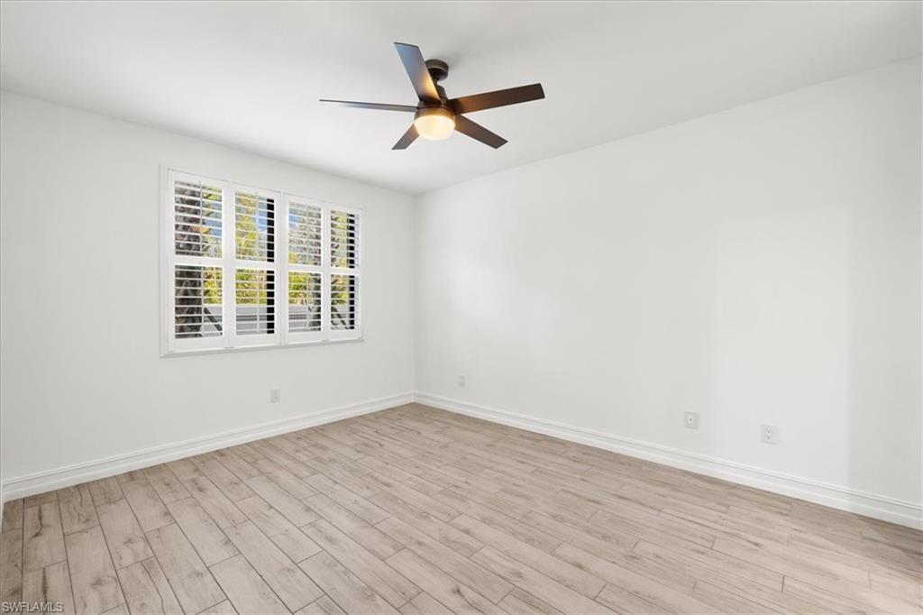 7622 Rockefeller Drive Naples, FL 34119 - Photo 25 of 40 wooden floor in an empty room with a window