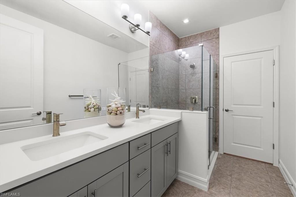 7622 Rockefeller Drive Naples, FL 34119 - Photo 29 of 40 a bathroom with a sink double vanity and a mirror