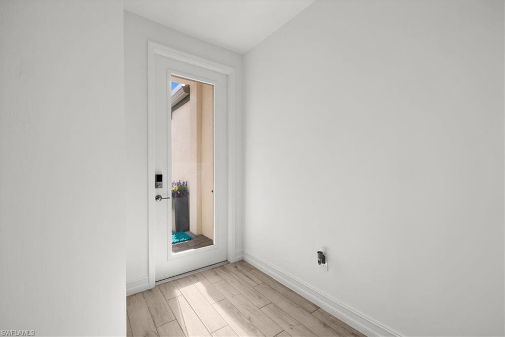 7622 Rockefeller Drive Naples, FL 34119 - Photo 4 of 40 a view of an empty room with wooden floor and a window